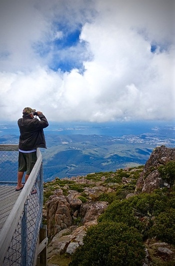 男子用望远镜观察悬崖