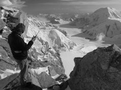 man on mountain holding walkie talkie