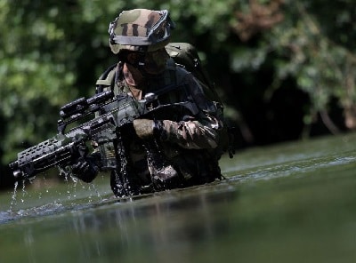 士兵站在水里，枪上有红点瞄准镜