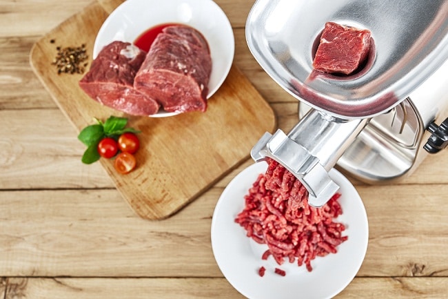 鲜肉，砧板和绞肉机放在餐桌上