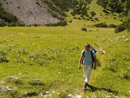 在一个阳光明媚的日子里，一名男子在草原上徒步旅行