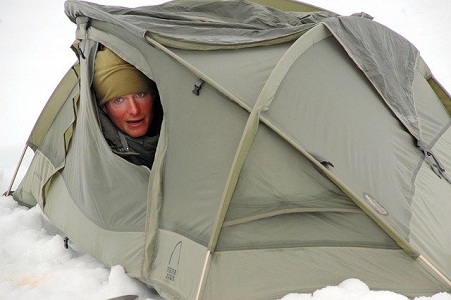 男子在雪地上挖帐篷