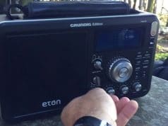 man tuning the Eton Grundig outdoors