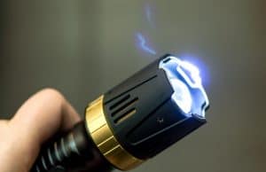 手握着手，打开手电筒，电击枪