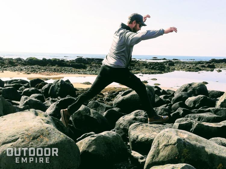冰岛海滩上，一名男子从一块巨石跳到另一块巨石上