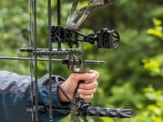 用复合弓瞄准箭的人