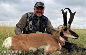 Hunter with recently shot pronghorn buck