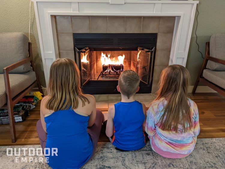 三个孩子坐在壁炉前