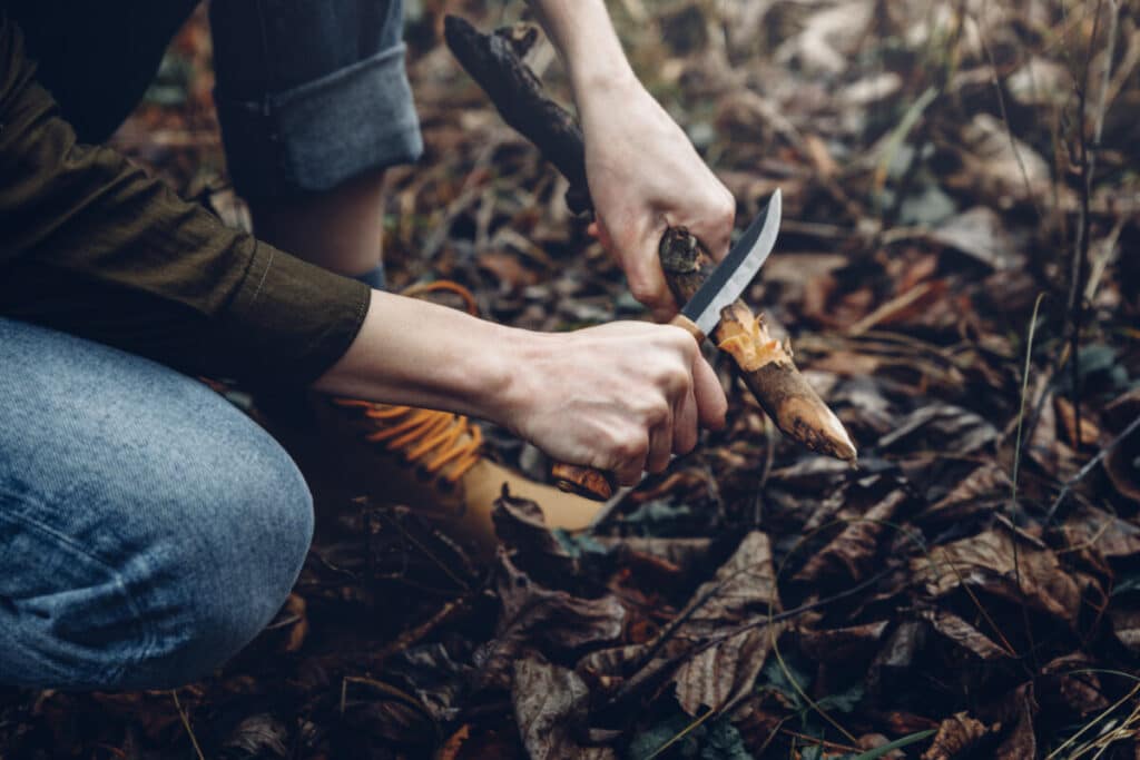 女人用刀刮树枝