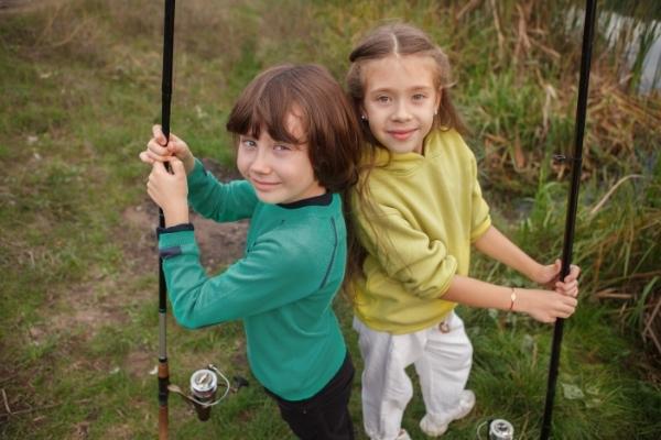 两个孩子拿着钓鱼竿