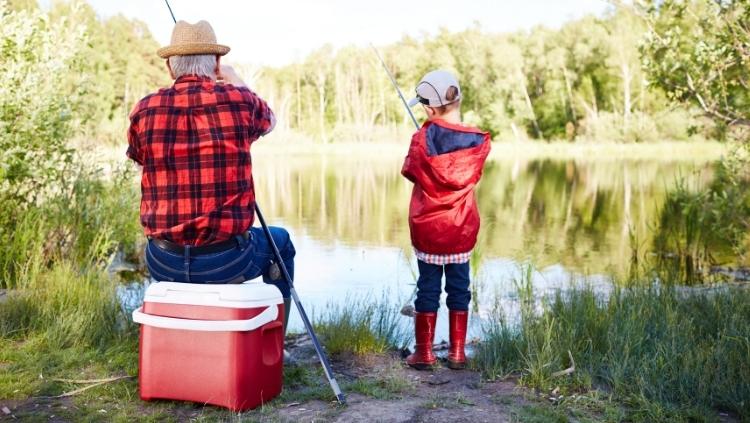 回来的爷爷和孩子在河边钓鱼