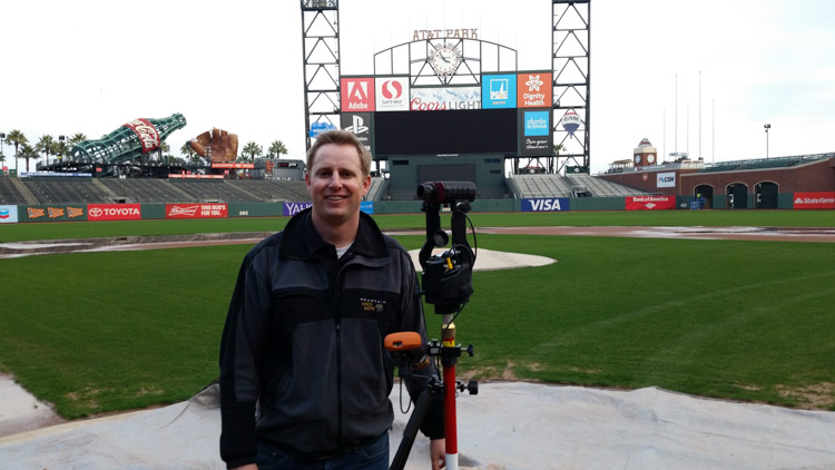 一名男子站在旧金山巨人体育场，手里拿着激光测距仪