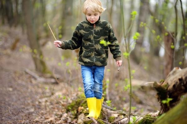 穿着雨靴的孩子在树林里散步