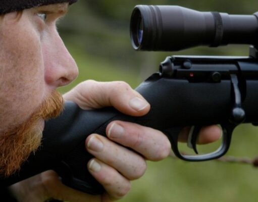 一个男人透过步枪瞄准镜看