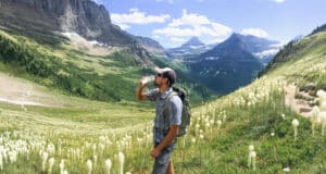 人在高山草甸徒步旅行和饮用水