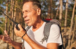 带着对讲机在树林里远足的人